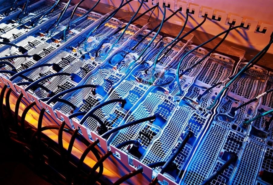 This image shows a high-performance data centre server rack using liquid cooling technology to efficiently manage heat in densely packed computing units.