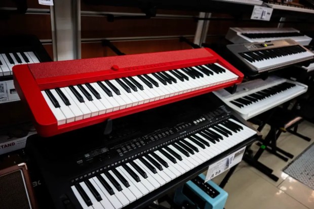Two Casio keyboards, one red, one black, stacked above one another.