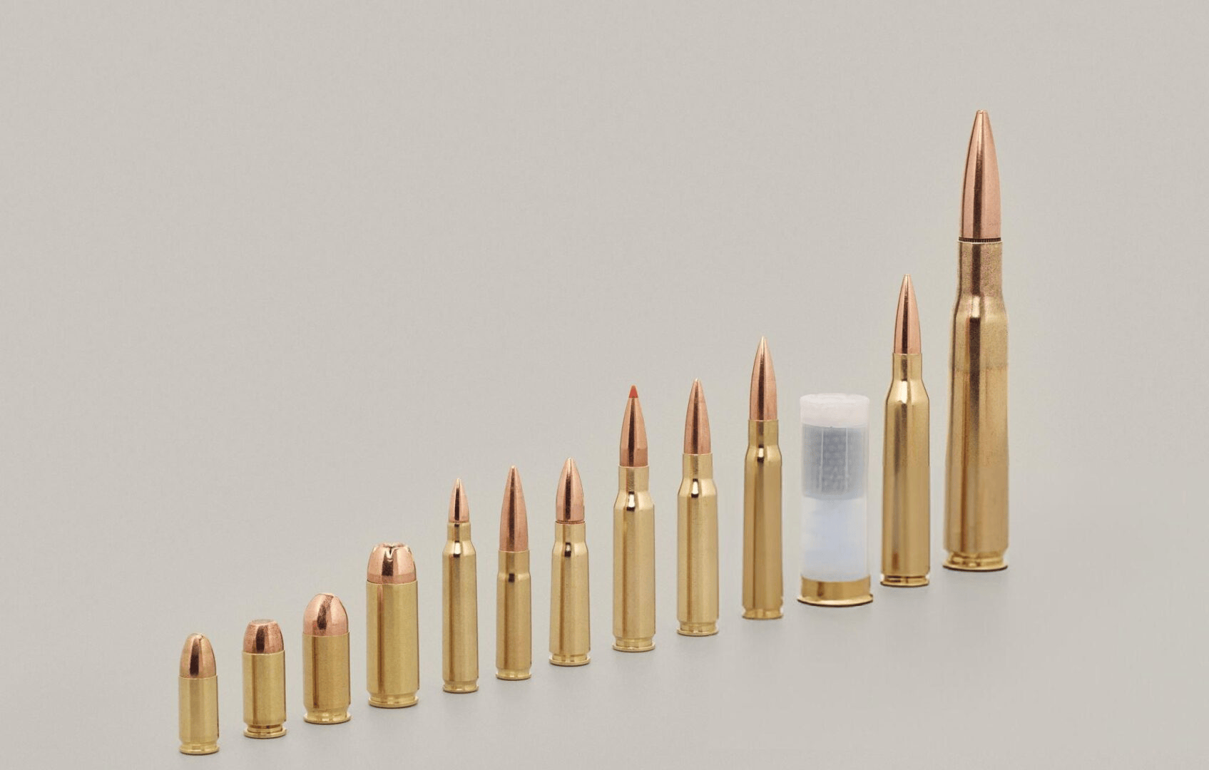 Variety of bullet cartridges on beige background - stock photo