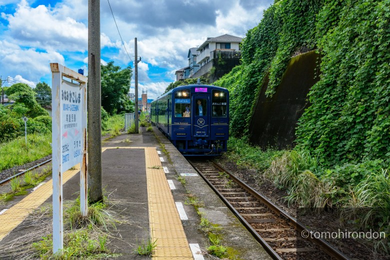 南鹿児島駅の駅名標と入線する「おれんじ食堂」。