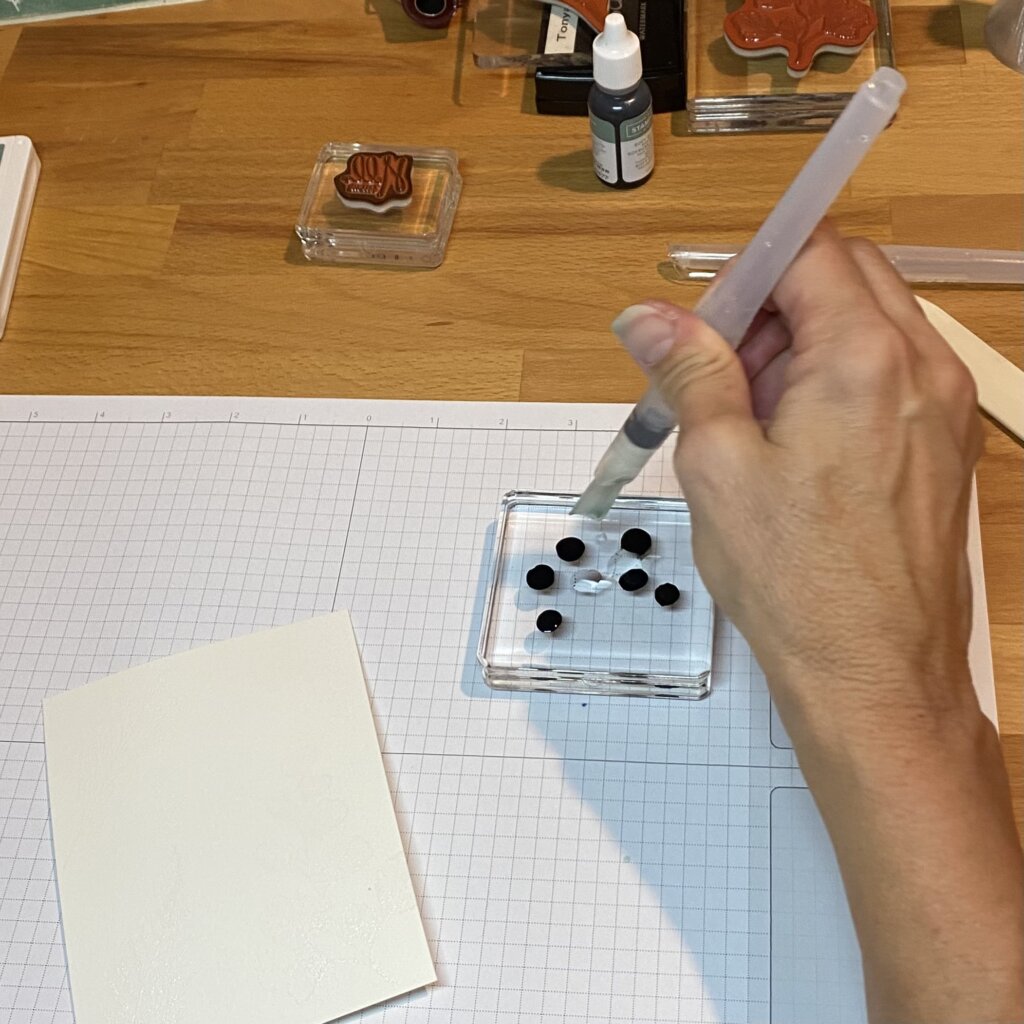 Squeeze drops of ink onto clear block and add drop of water