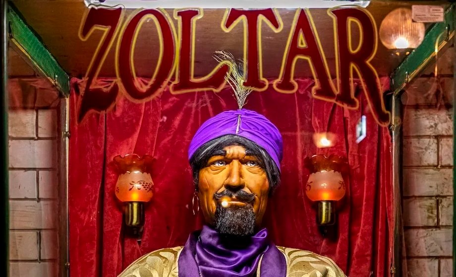 A Zoltar fortune teller machine with a turbaned mannequin behind glass