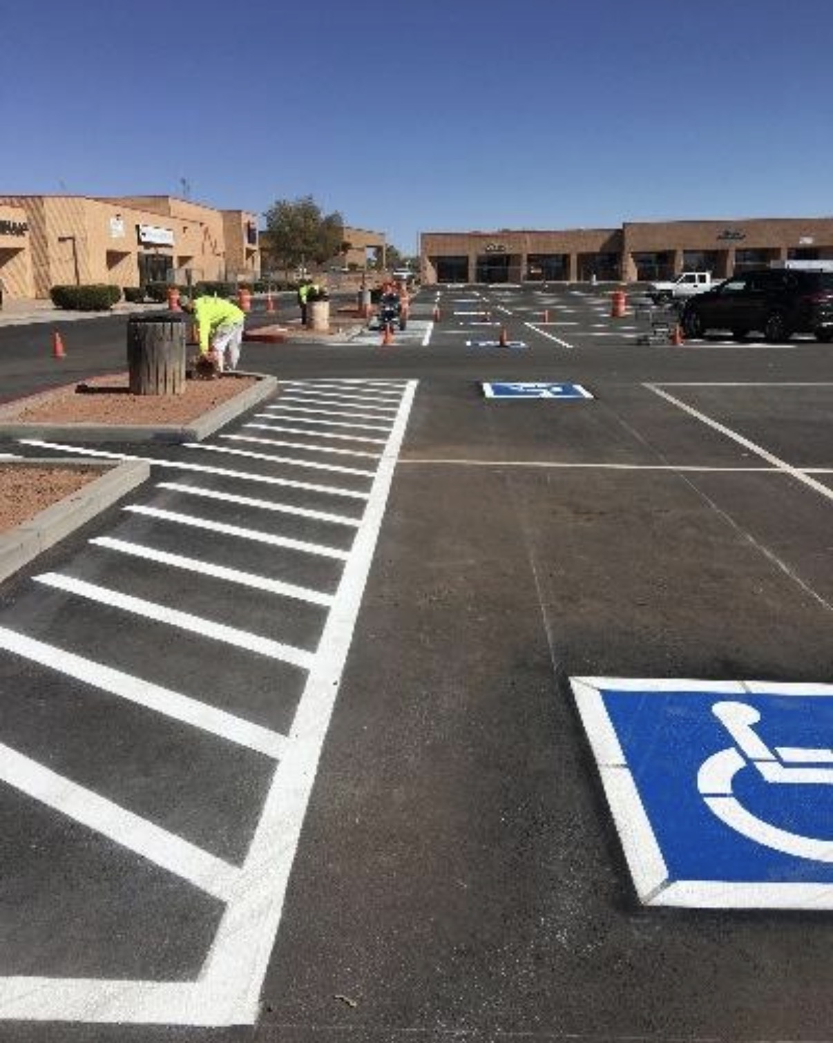 Fresh white crosswalk and ADA parking symbol on a commercial lot