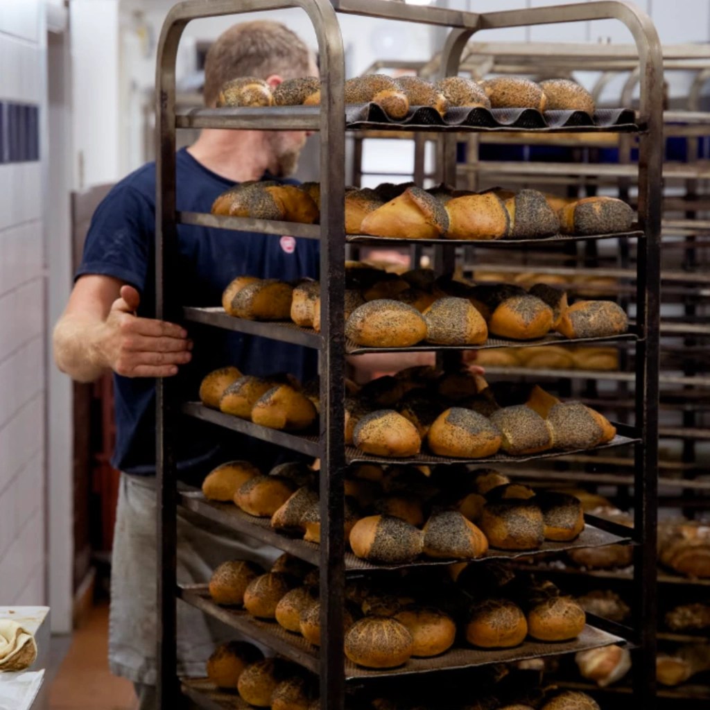 Friskbagte rundstykker med birkes på bageplader i bageriet i Skagen