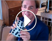 Video still with a play button in the center showing Larry Lewis of Flying Blind, LLC holding a BraillePen12.