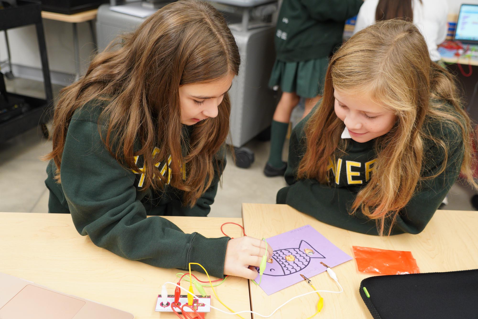 Grade 6 students looking at an electronic game project.