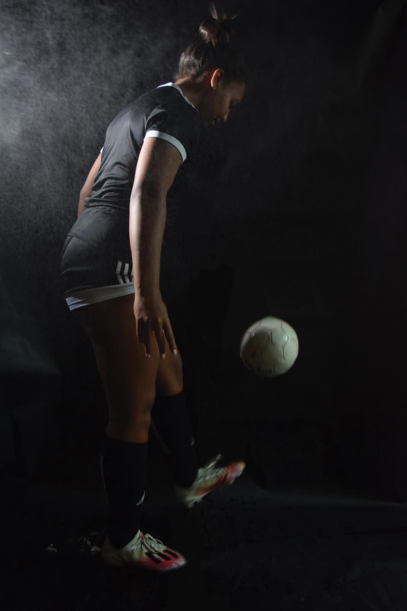 Photo of someone bouncing a soccer ball on their foot.