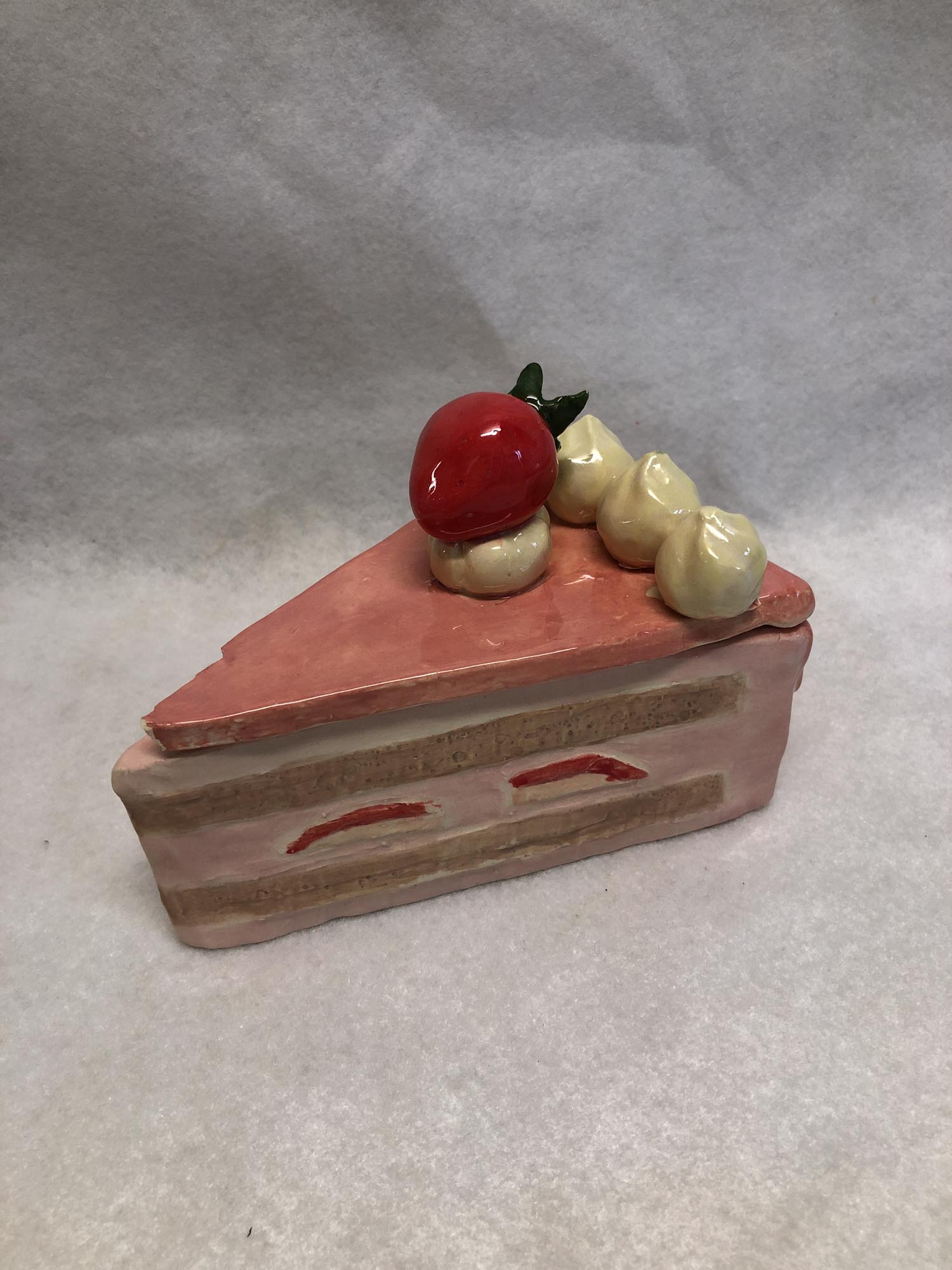 Photo of student artwork by Angela Y. in Grade 7 depicting a slice of cake made of clay
