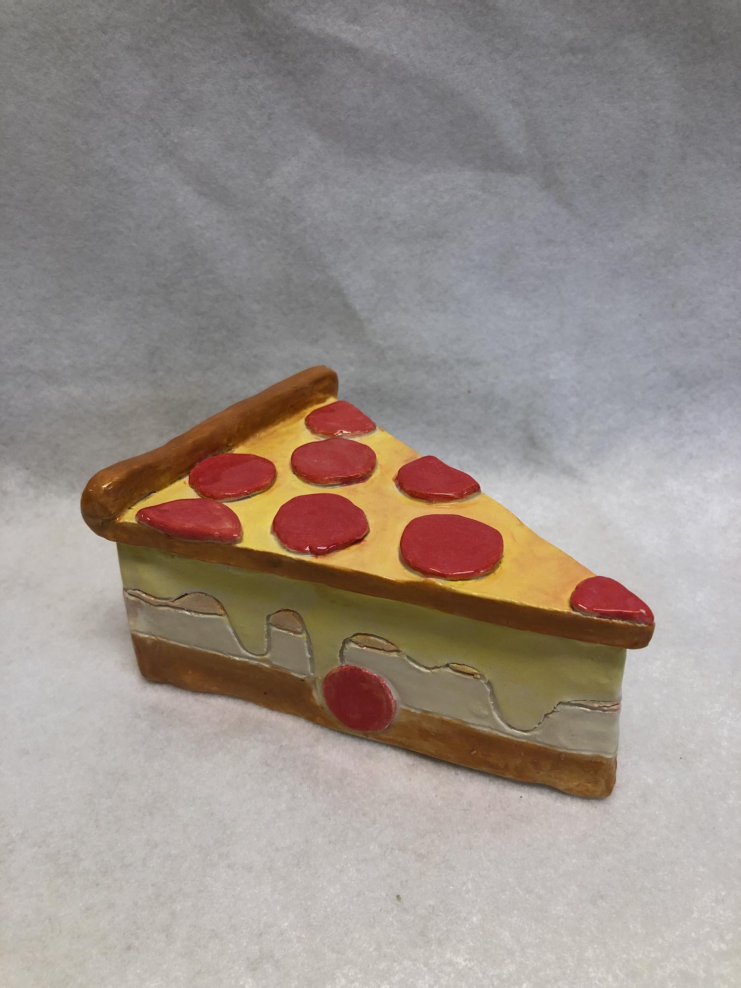 Photo of student artwork by Ashley C. in Grade 7 depicting a slice of cake made of clay