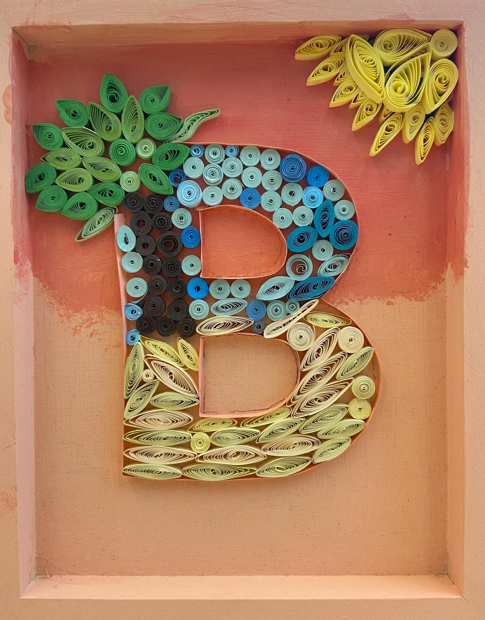 The letter B made from quill art.