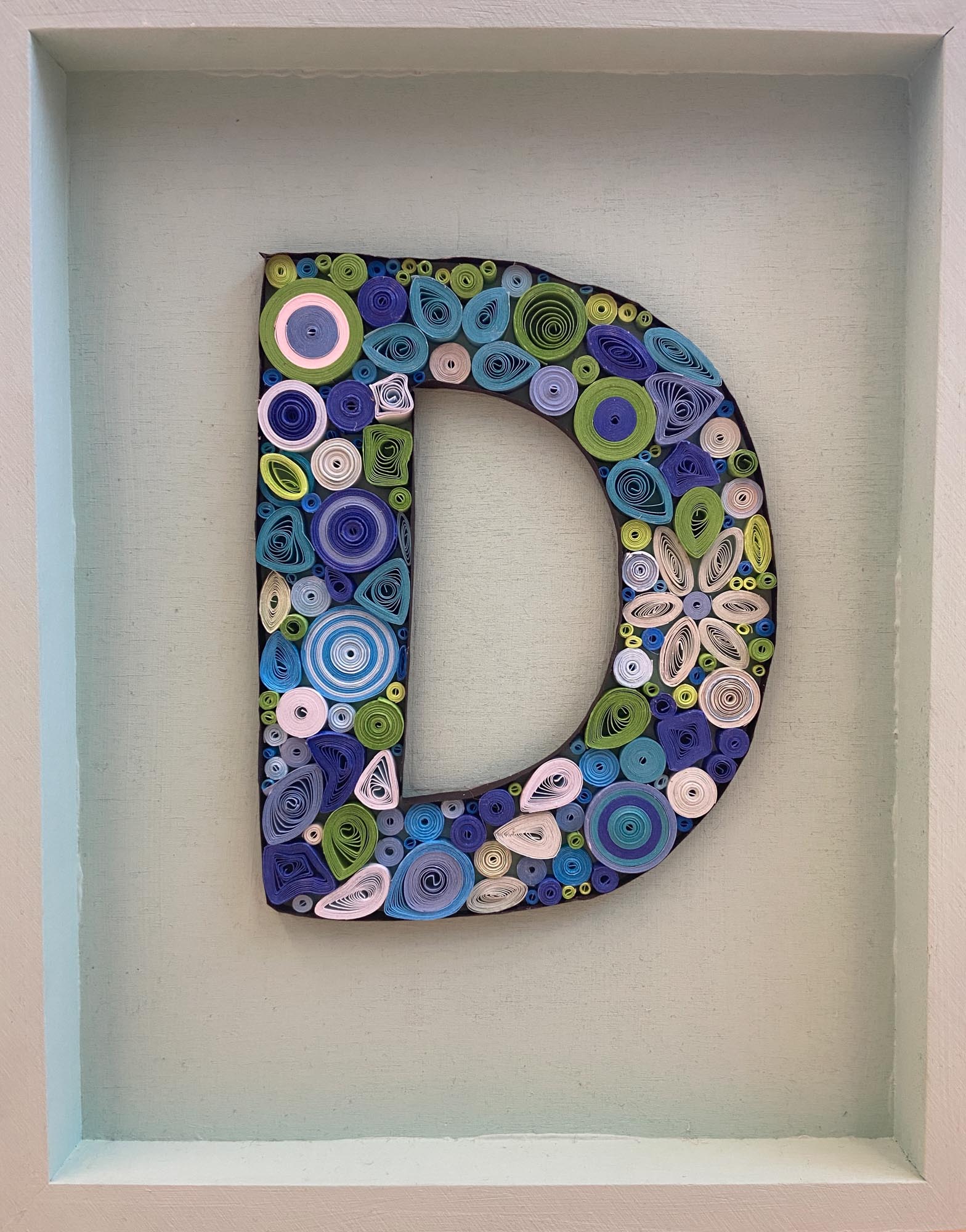 The letter D made from quill art.
