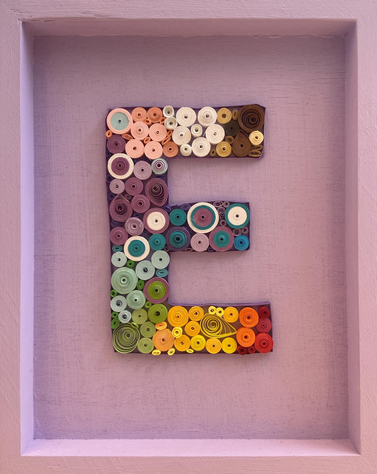 The letter E made from quill art.