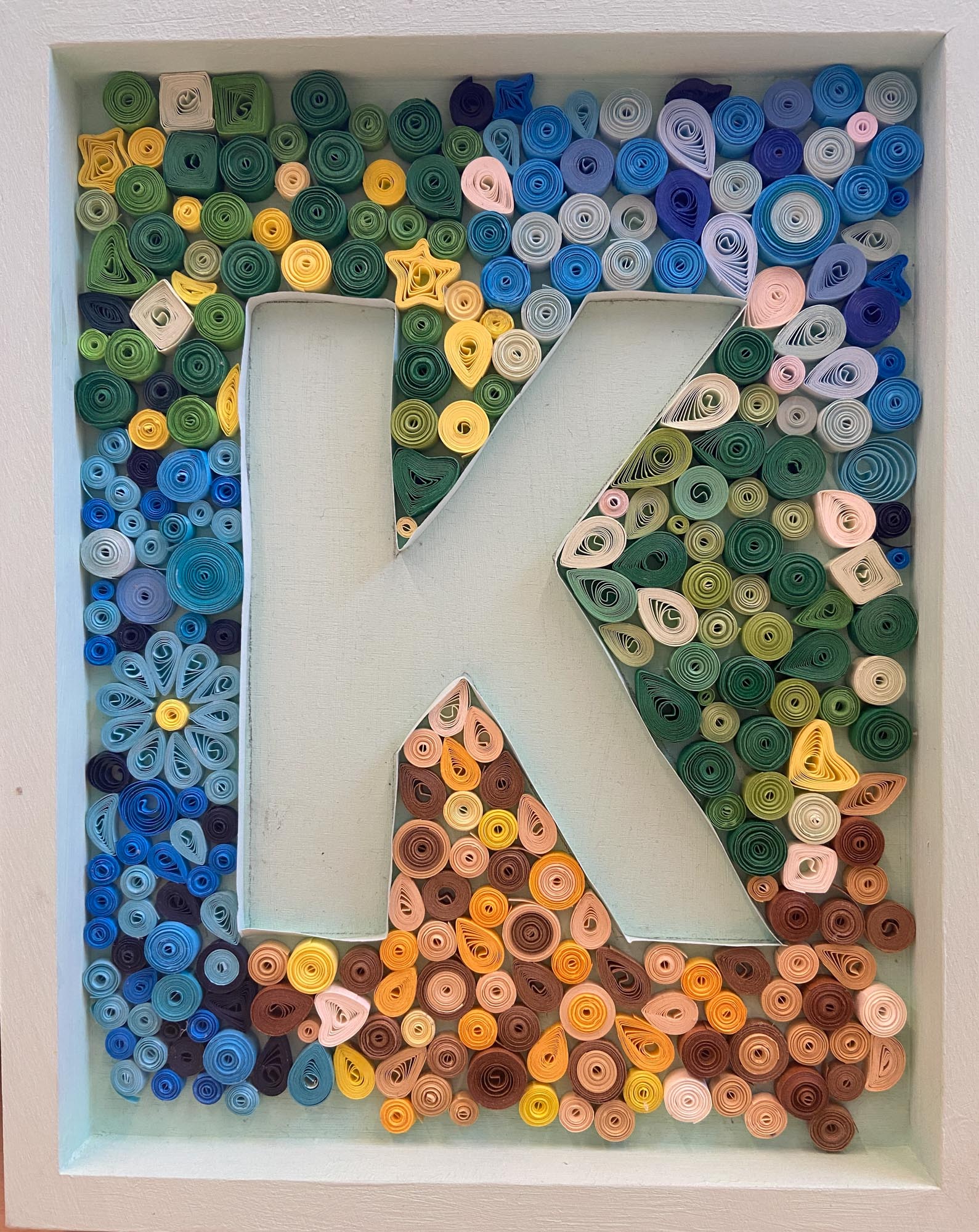 The letter K made from quill art.