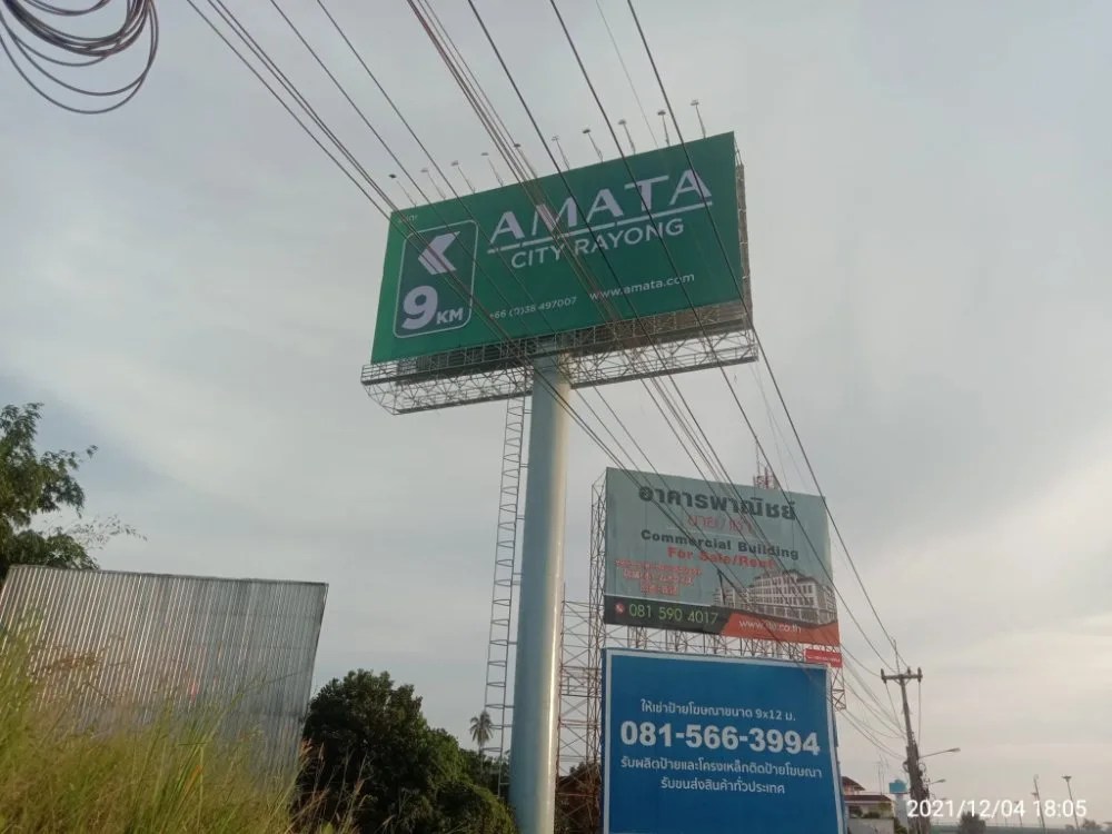 Green directional billboard on a steel structure beside a highway