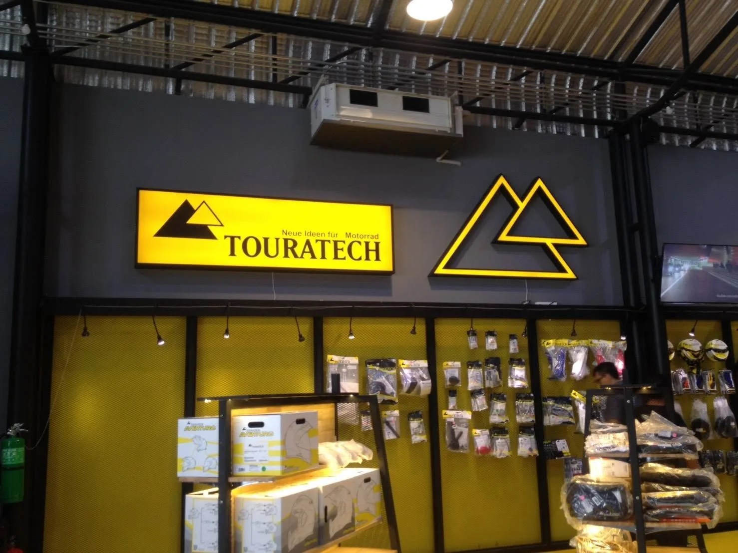 Yellow lightbox and outline logo in a motorcycle accessory showroom