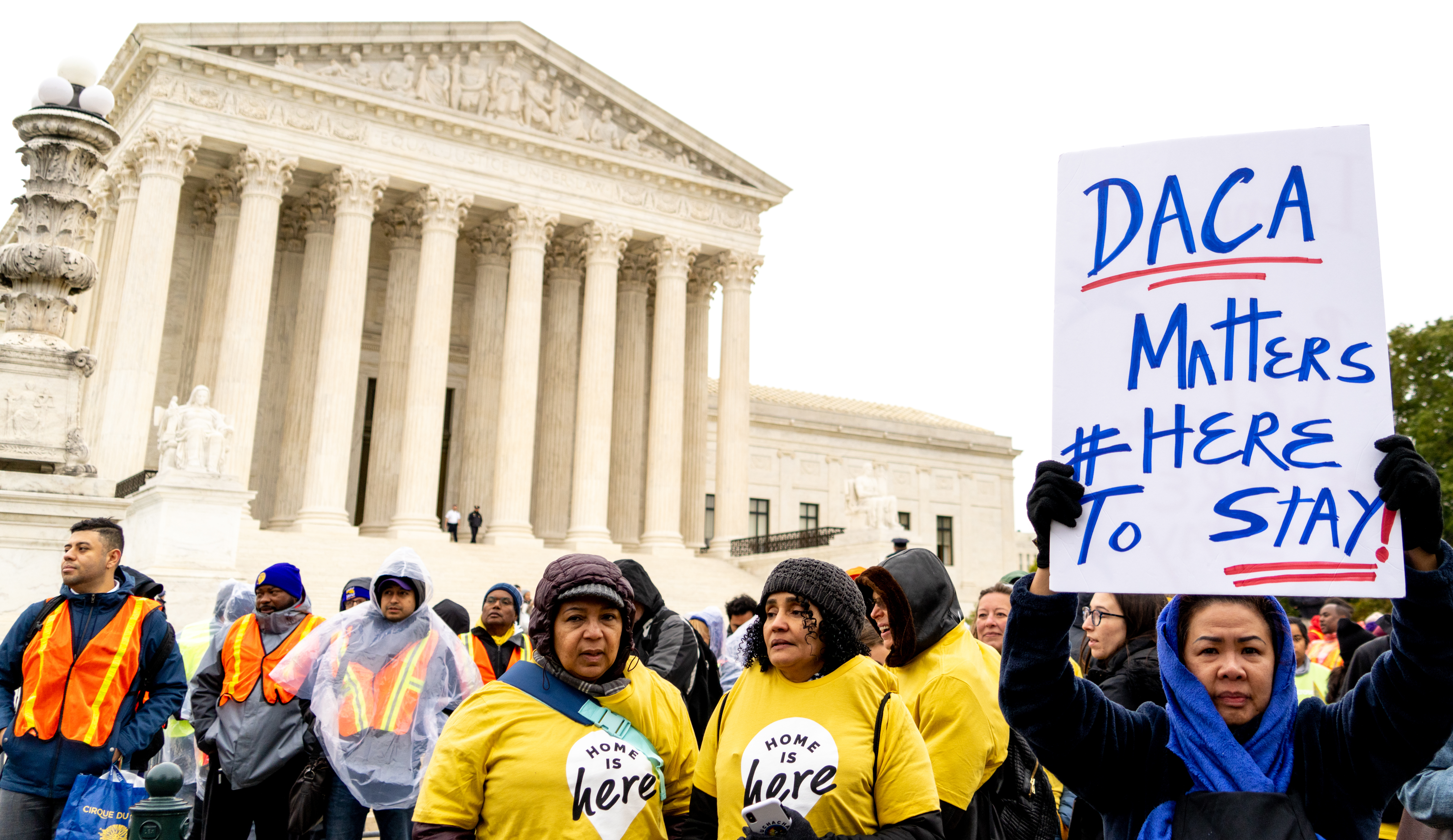 A protester holds a "DACA Matters #Here To Stay!" sign in front of the U.S. Supreme Court building.