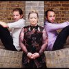 Saul Rose, Eliza Carthy and Dave Delarre, sitting on a wall and looking into the camera.