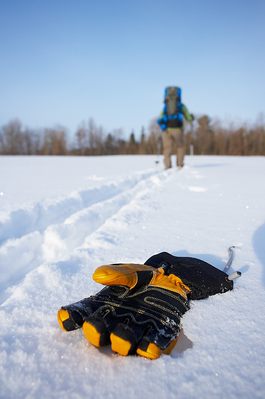 glove in snow beside trail