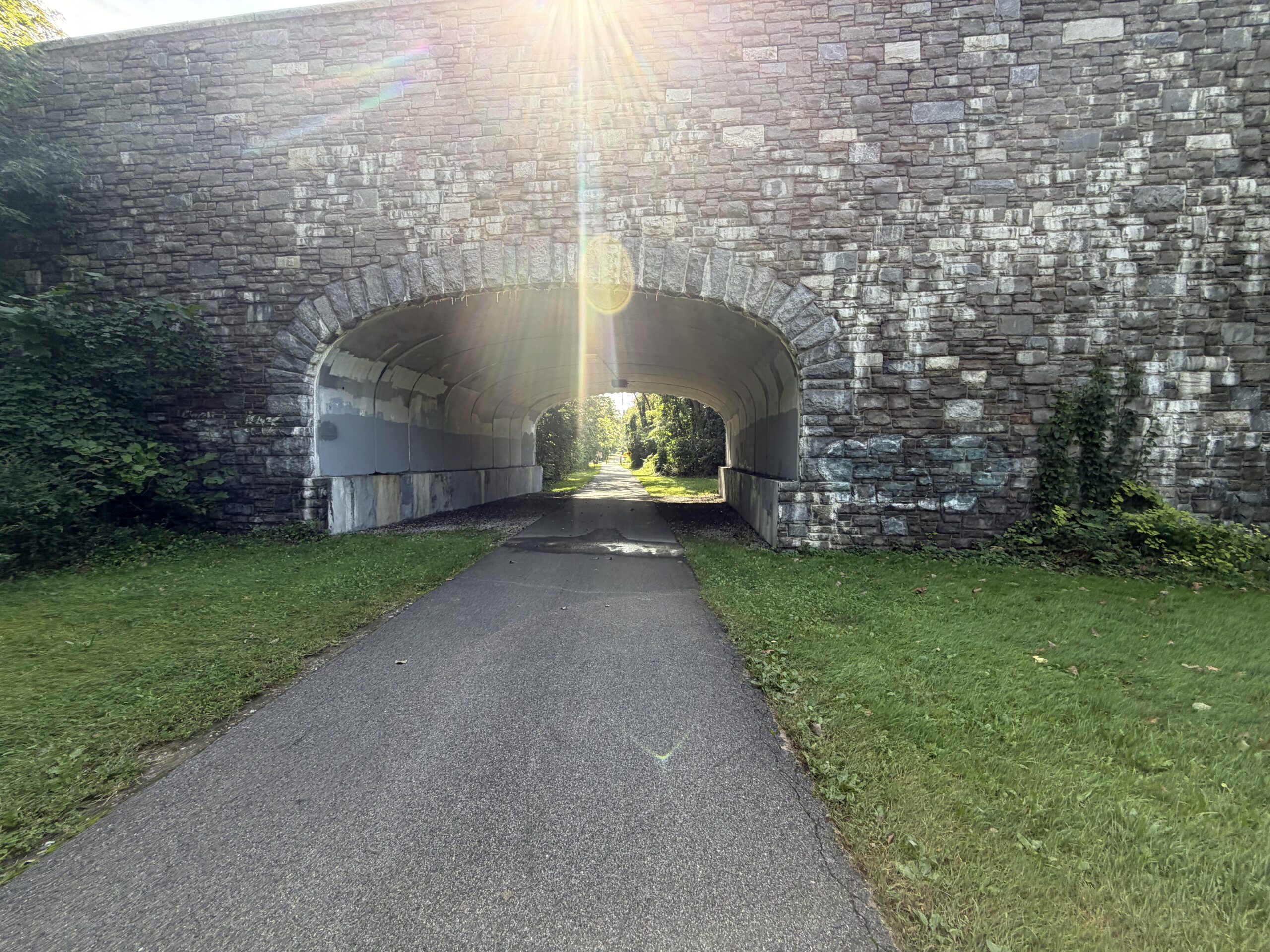 Empire State Trail passing beneath a stone archway in the New York metropolitan area