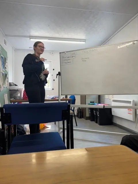 a student standing in front of the class leading a game.