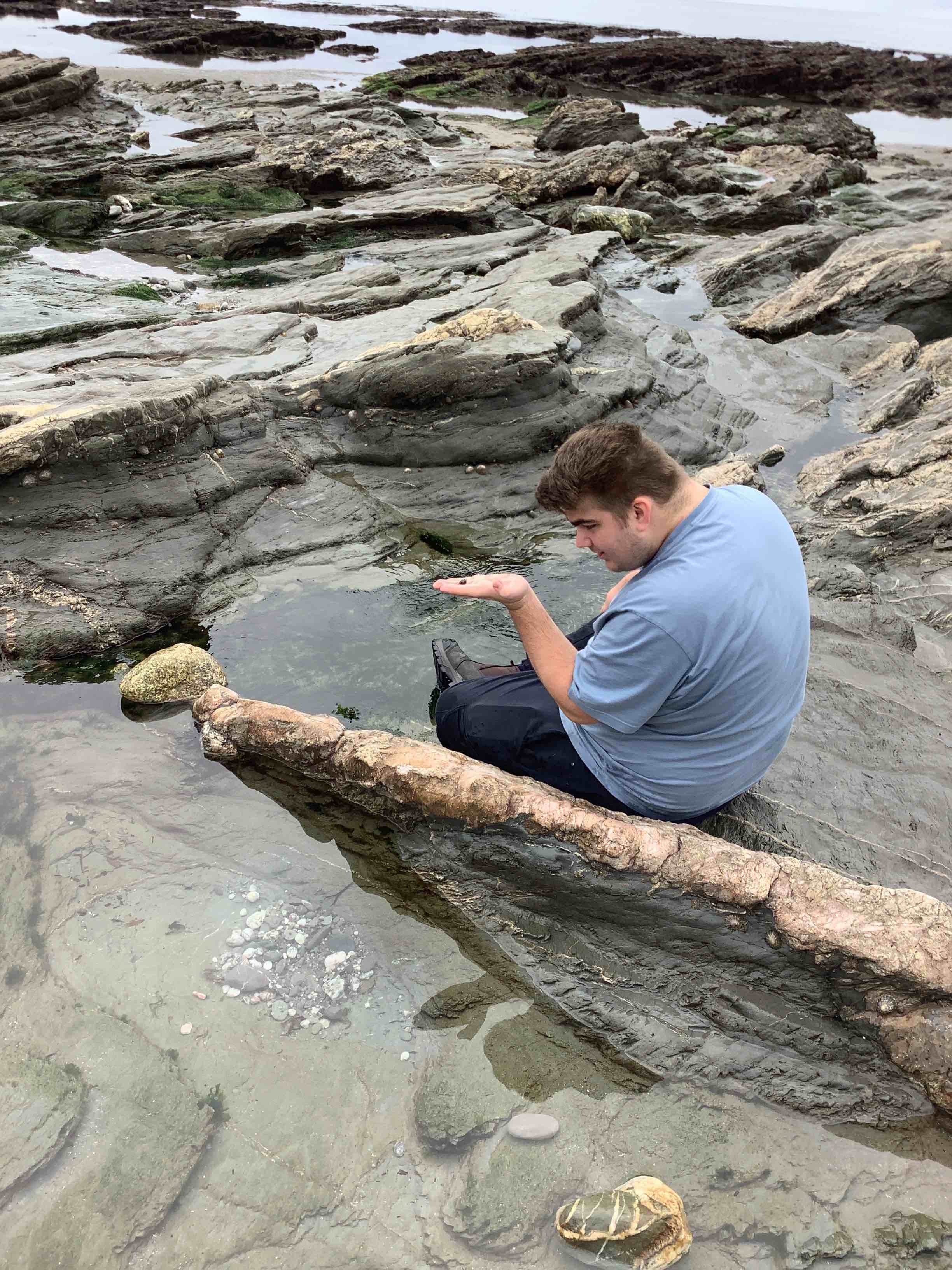 young man rockpooling at downderry beach