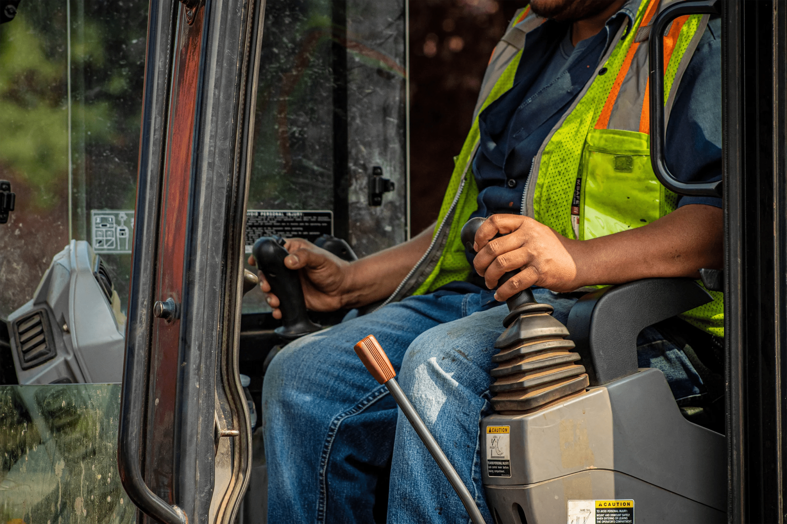 cropped photo of mobile equipment operator sitting in cab of equipment
