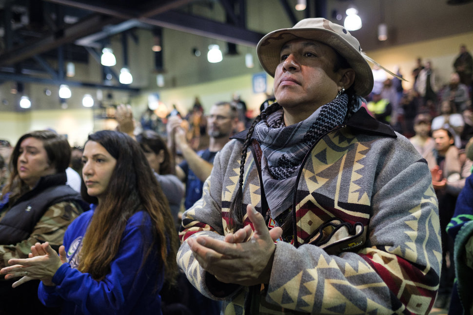 Doug Good Feather, a U.S. Army veteran, claps as Ivan Looking Horse gives a speech during a forgiveness ceremony for veterans at the Four Prairie Knights Casino & Resort on the Standing Rock Sioux Reservation on Monday, Dec. 5, 2016.