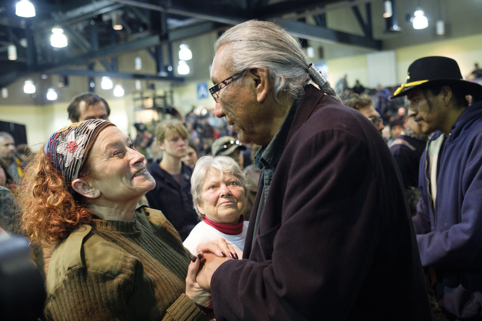 U.S. Air Force veteran Virginia McIntyre, left, shakes hands with chief Arvol Looking Horse during a forgiveness ceremony for veterans at the Four Prairie Knights Casino & Resort on the Standing Rock Sioux Reservation on Monday, Dec. 5, 2016.