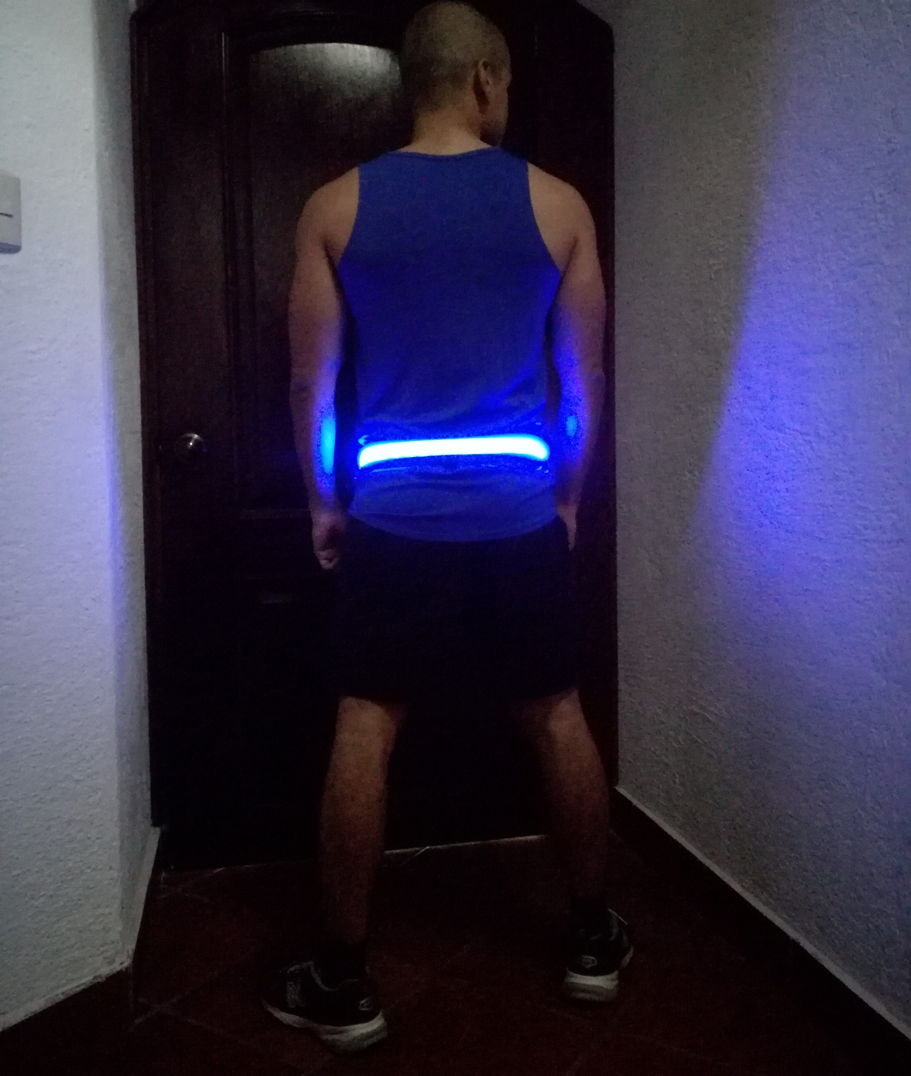 man wearing a blue tank shirt with a led belt on his weist