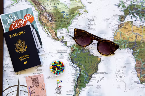 glasses and passport on top of a map