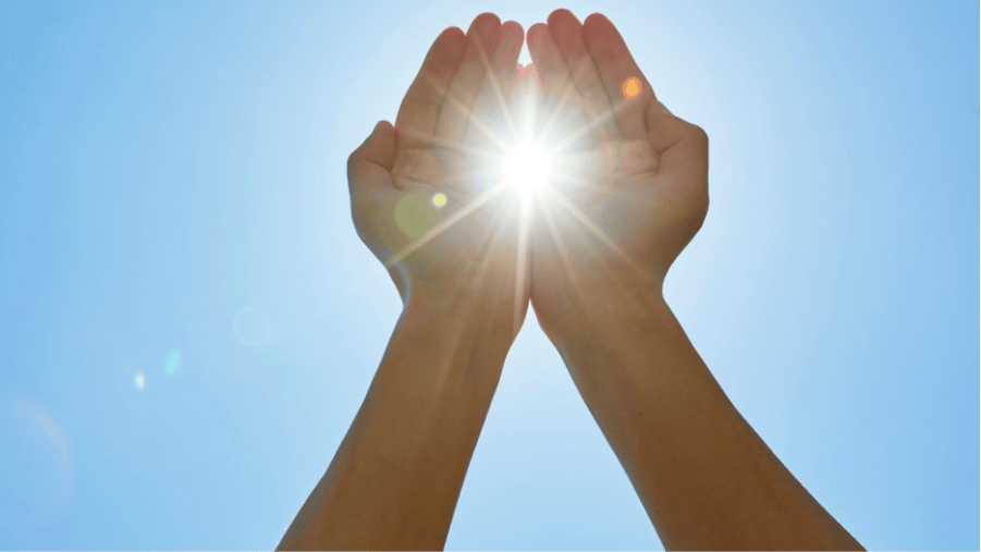 hands shielding from or embracing the sun's rays