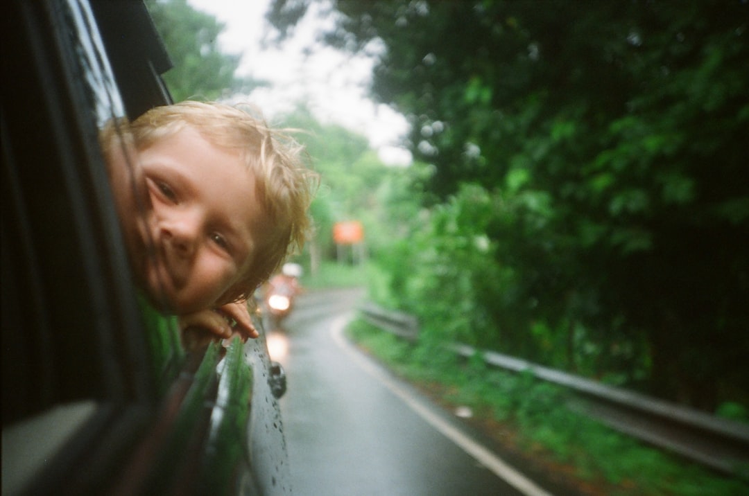 Things You NEED to Carry on Your Next Family Road Trip! child peeking from vehicle window while on road trip