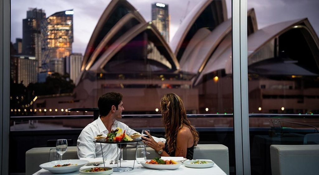 Couple enjoying a romantic dinner on Clearview Glass Boat with the Sydney Opera House in the background