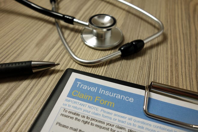 Travel insurance claim form with pen and stethoscope