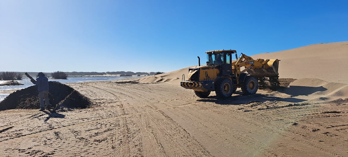 Montículos de arena sosteniendo pilotes en la laguna de la albufera de Reta