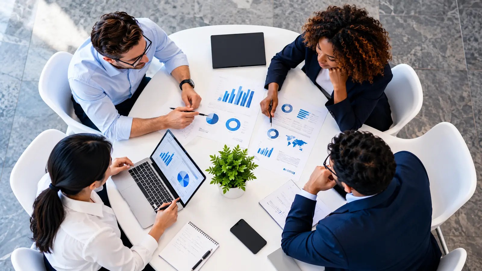 Consultants reviewing reports and dashboards around a meeting table