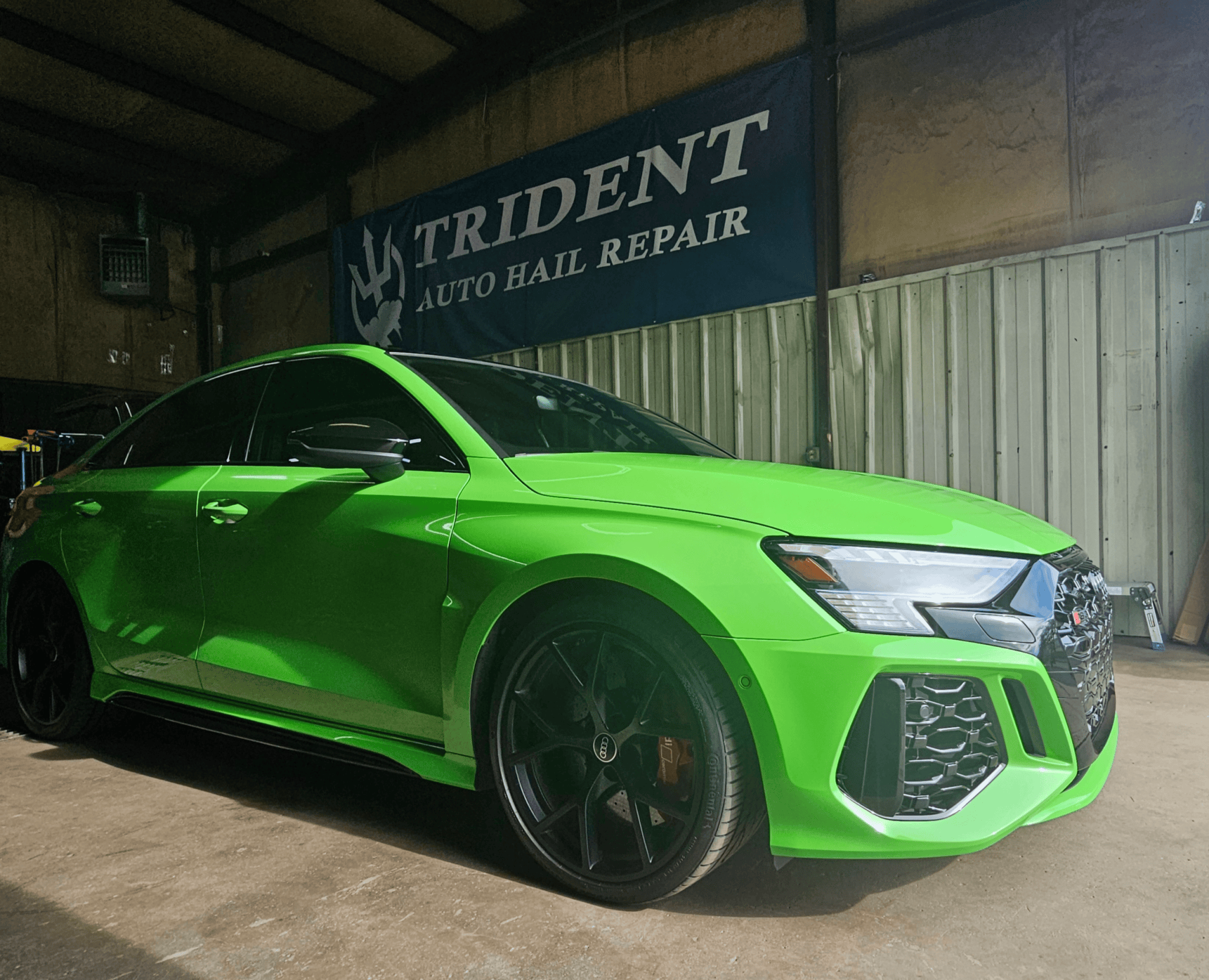 Green Audi at Trident hail repair shop in Colorado Springs inside shop - darker