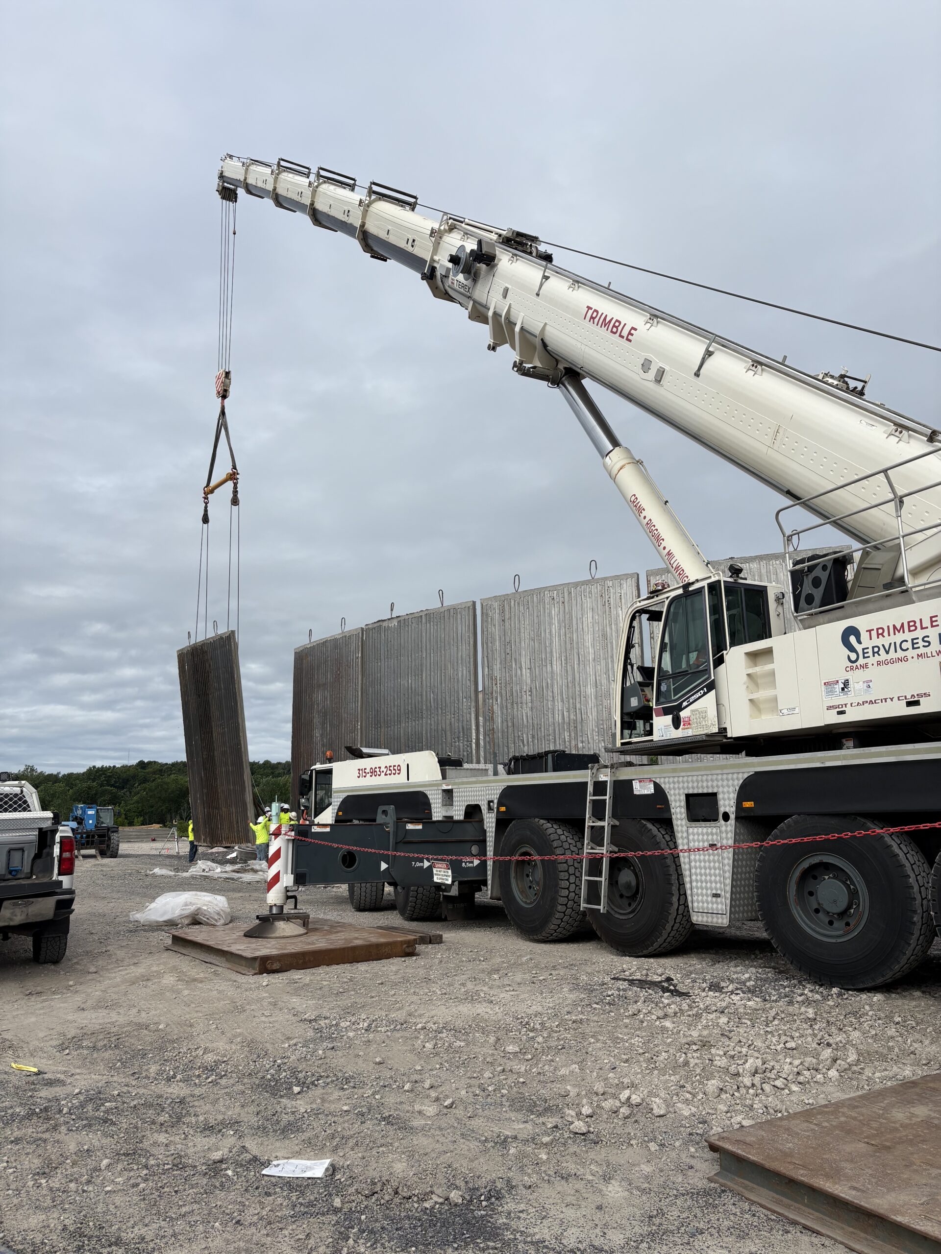 Trimble Services' 300-ton Terex Demag crane standing a precast concrete panel during water tank construction in Oswego, NY.