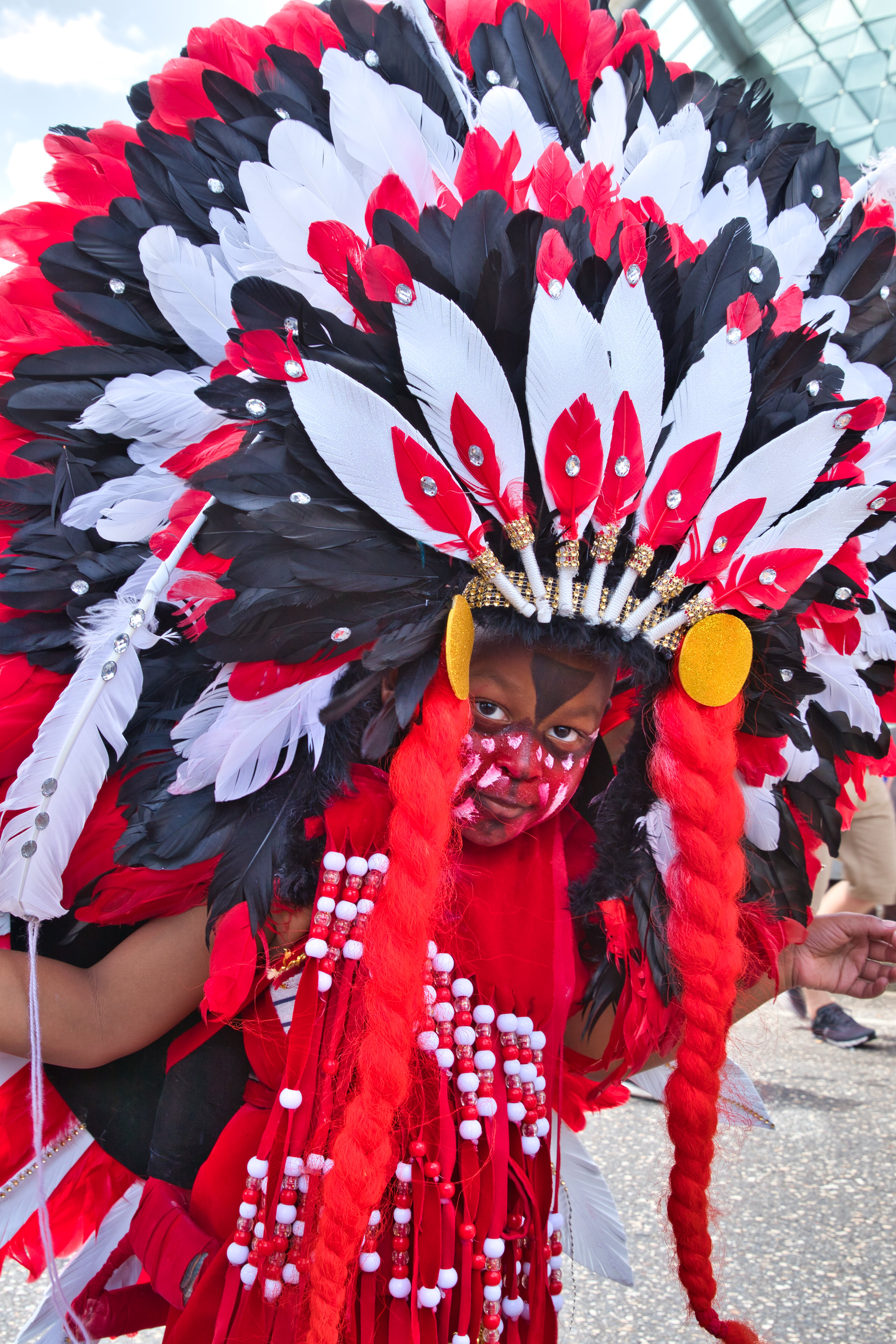Child in Carnival Costume: Red, White and Black feathers.