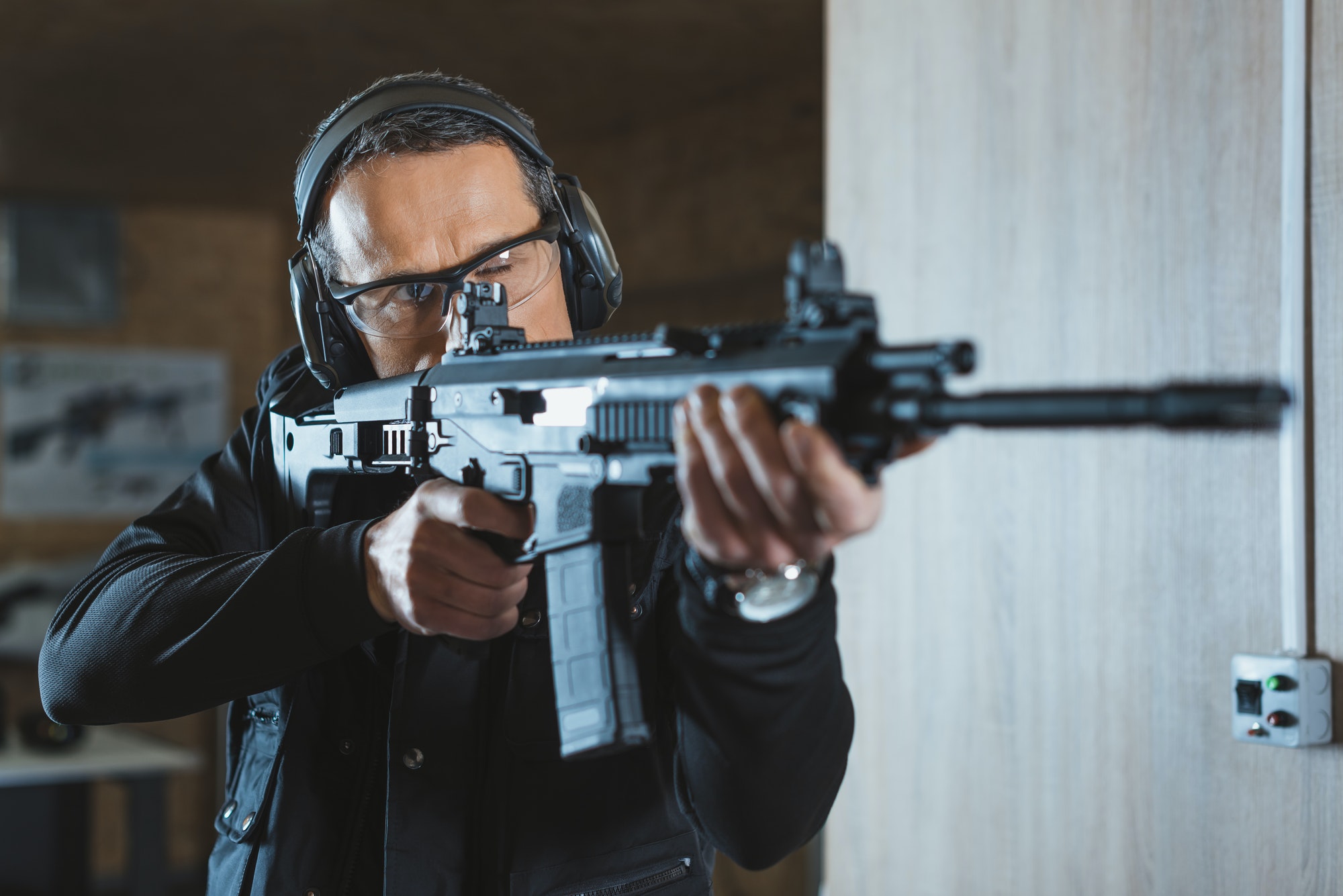 handsome-man-aiming-rifle-in-shooting-range.jpg