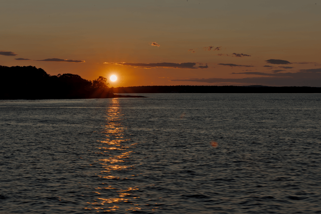 Sun setting behind a small island.