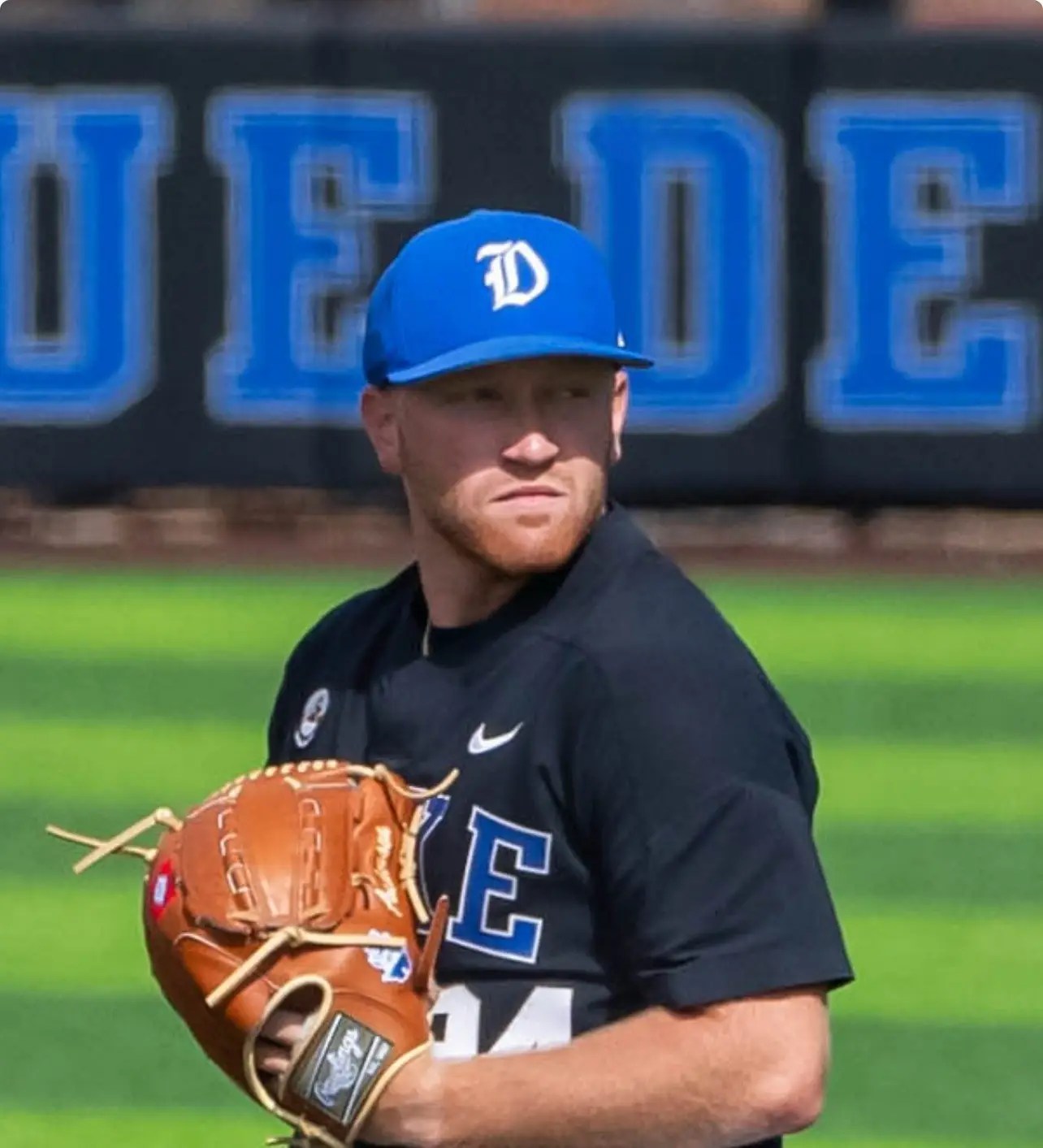 Duke baseball player holding glove at stadium