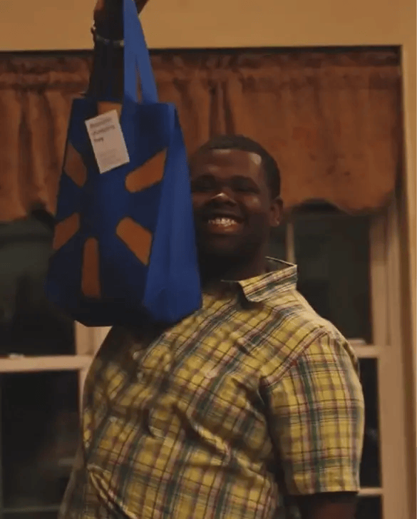 Duke athlete holding blue Duke merchandise bag