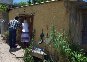 This elderly lady lives alone in a tiny one room adobe house.