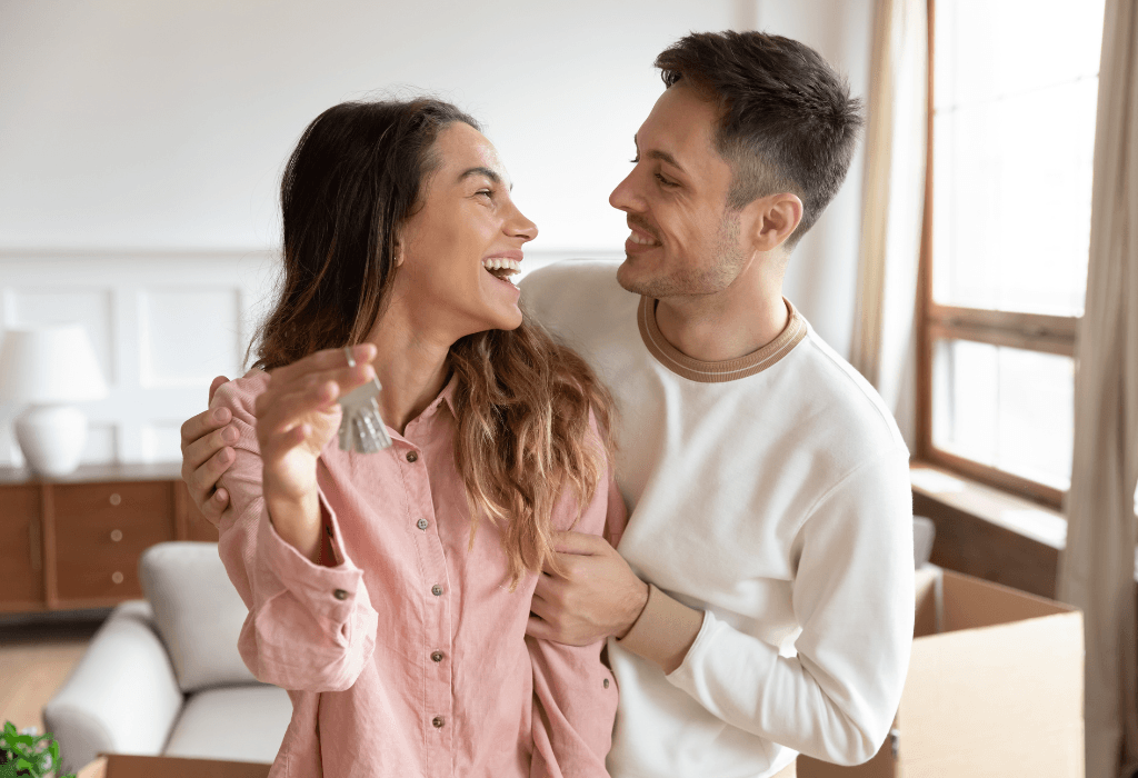 Happy homeowners holding house keys after choosing affordable, durable, and convenient home improvement solutions.