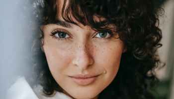 charming woman with freckles in room