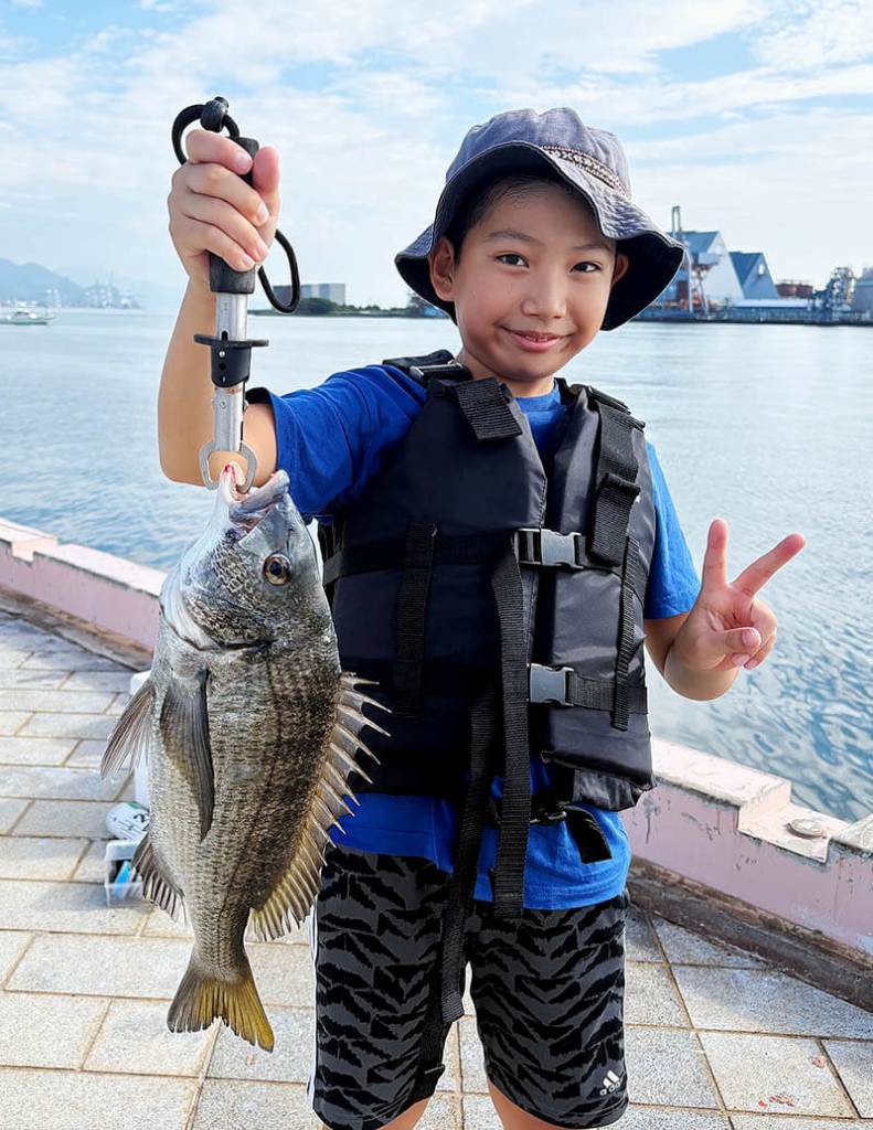 清水港日の出埠頭で行われた釣り開放・釣り体験教室の稚魚放流の様子