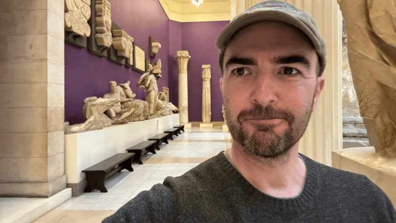 A photograph of Microscope RPG designer Ben Robbins in a museum.