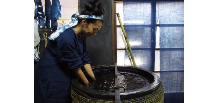 Teresa Misagal with her hands in a barrel of ink