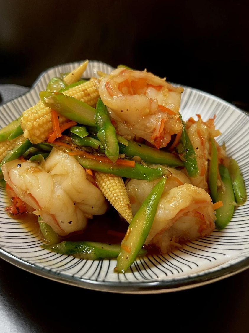 Sauté d'asperges avec de l'ail, des jeunes pousses de maïs et des crevettes tigrées